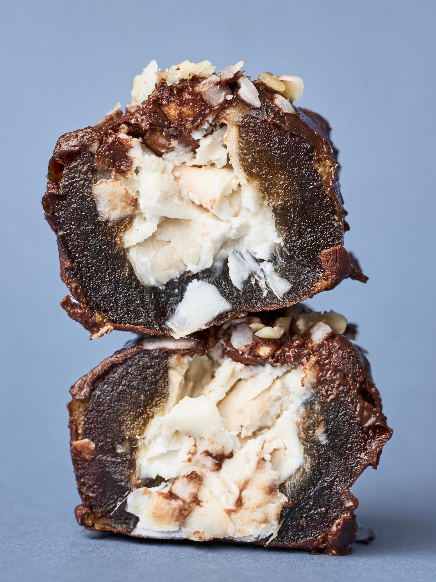Two halves of a PITT Coconut date stacked, coconut cream inside